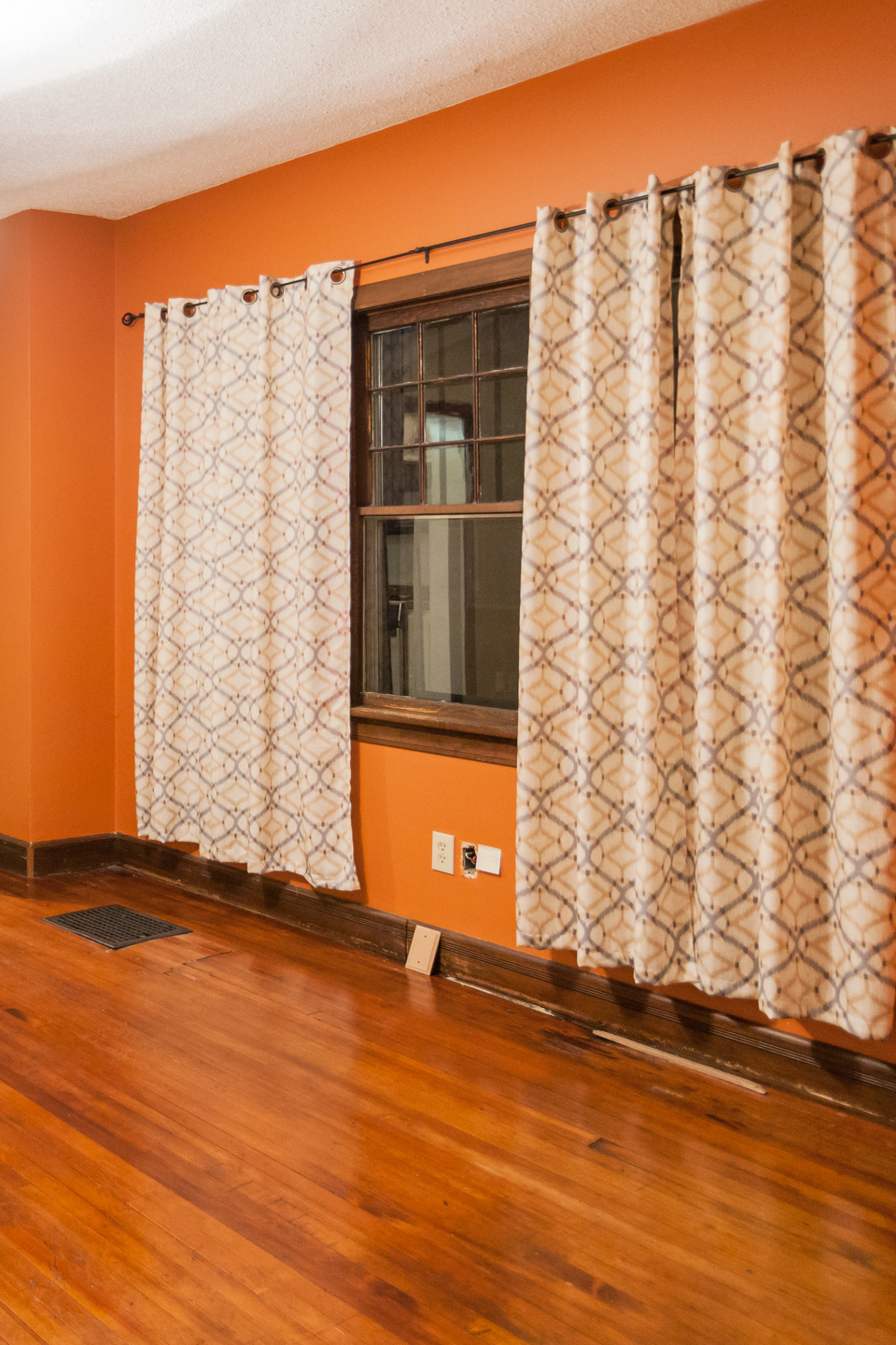 A before image of a dining room with an orange wall