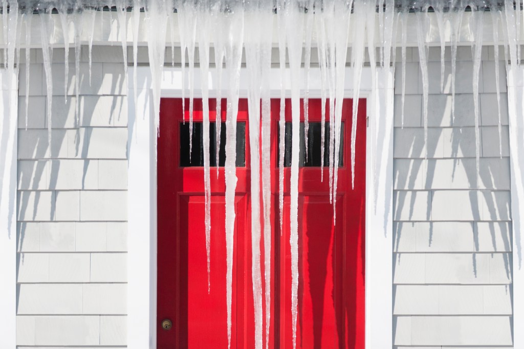 Icicles covering front of house in winter