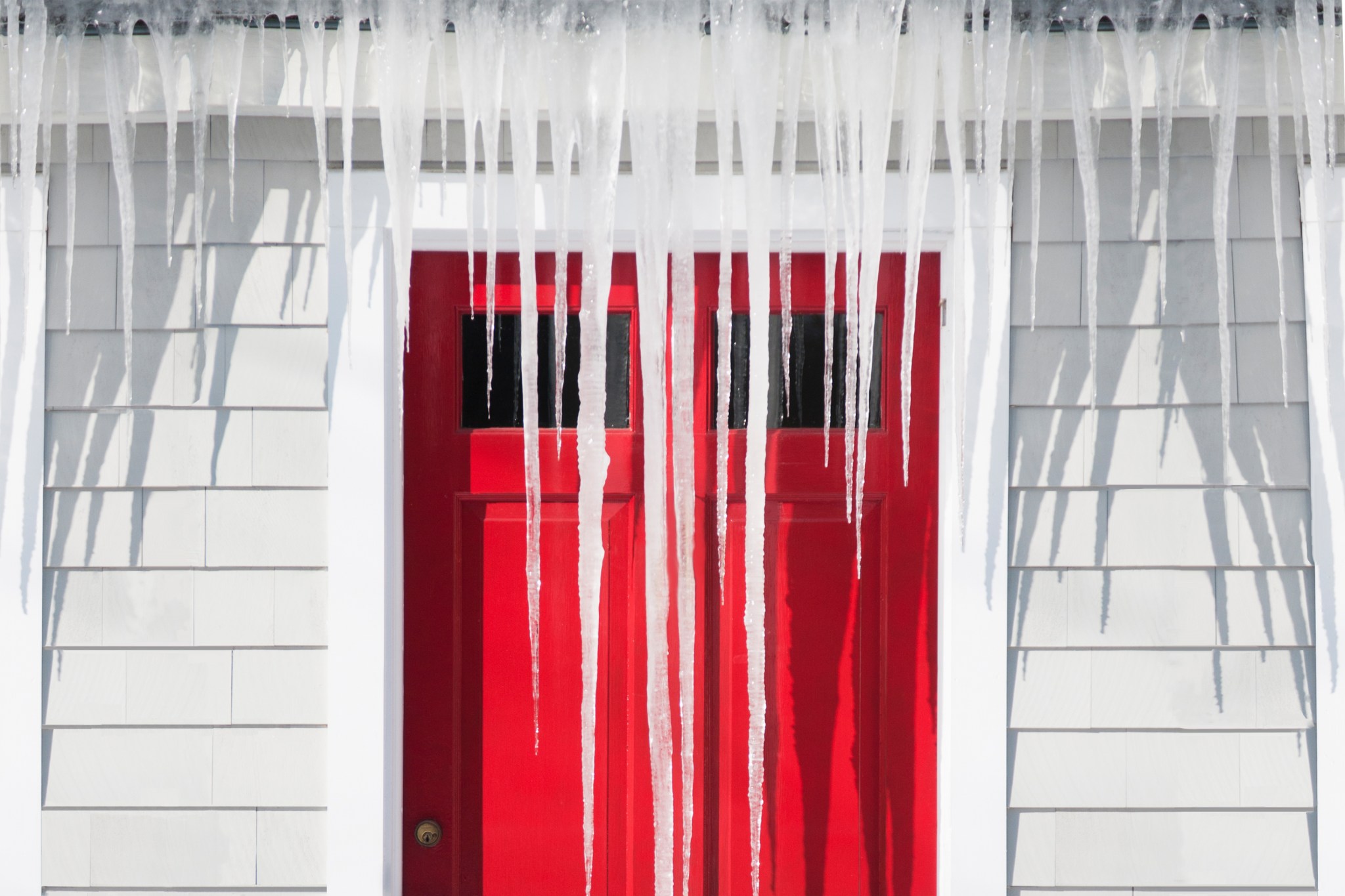 Icicles covering front of house in winter