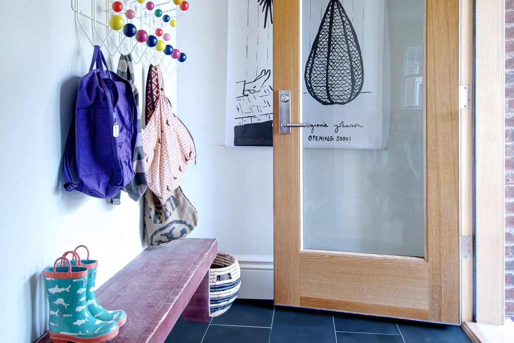 A bright entryway with colorful coat hanger and backpacks