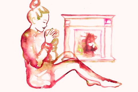 Woman staying warm by her home fireplace