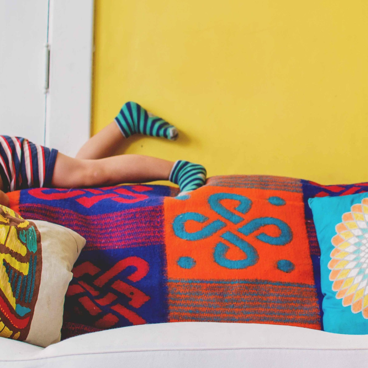 Eclectic home with colorful yellow wall and fun throw pillow