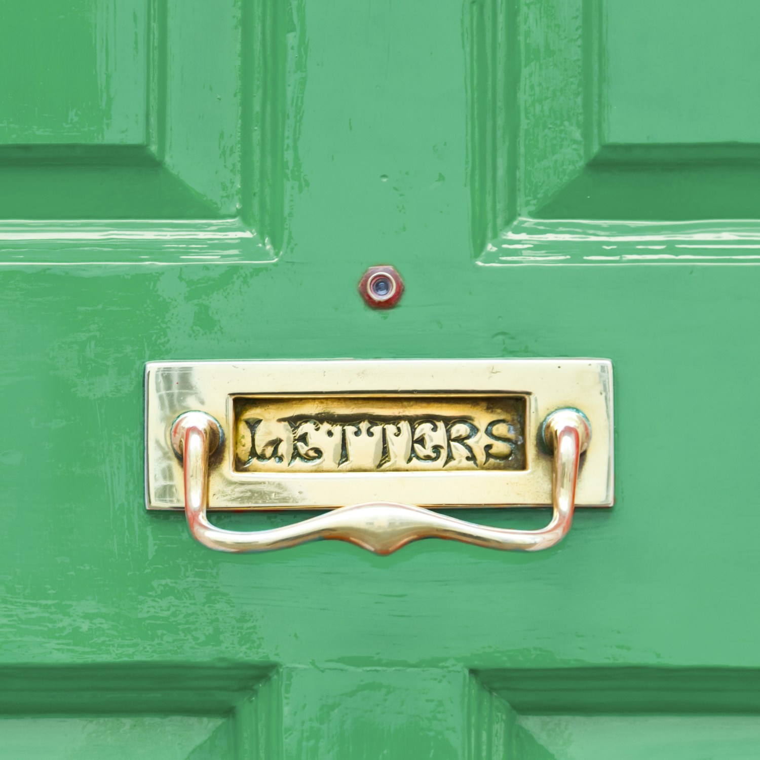 Bright green wood entry door with built-in mailbox