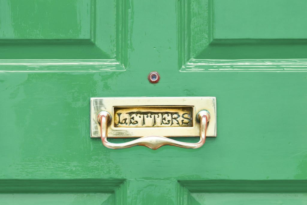 Bright green wood entry door with built-in mailbox