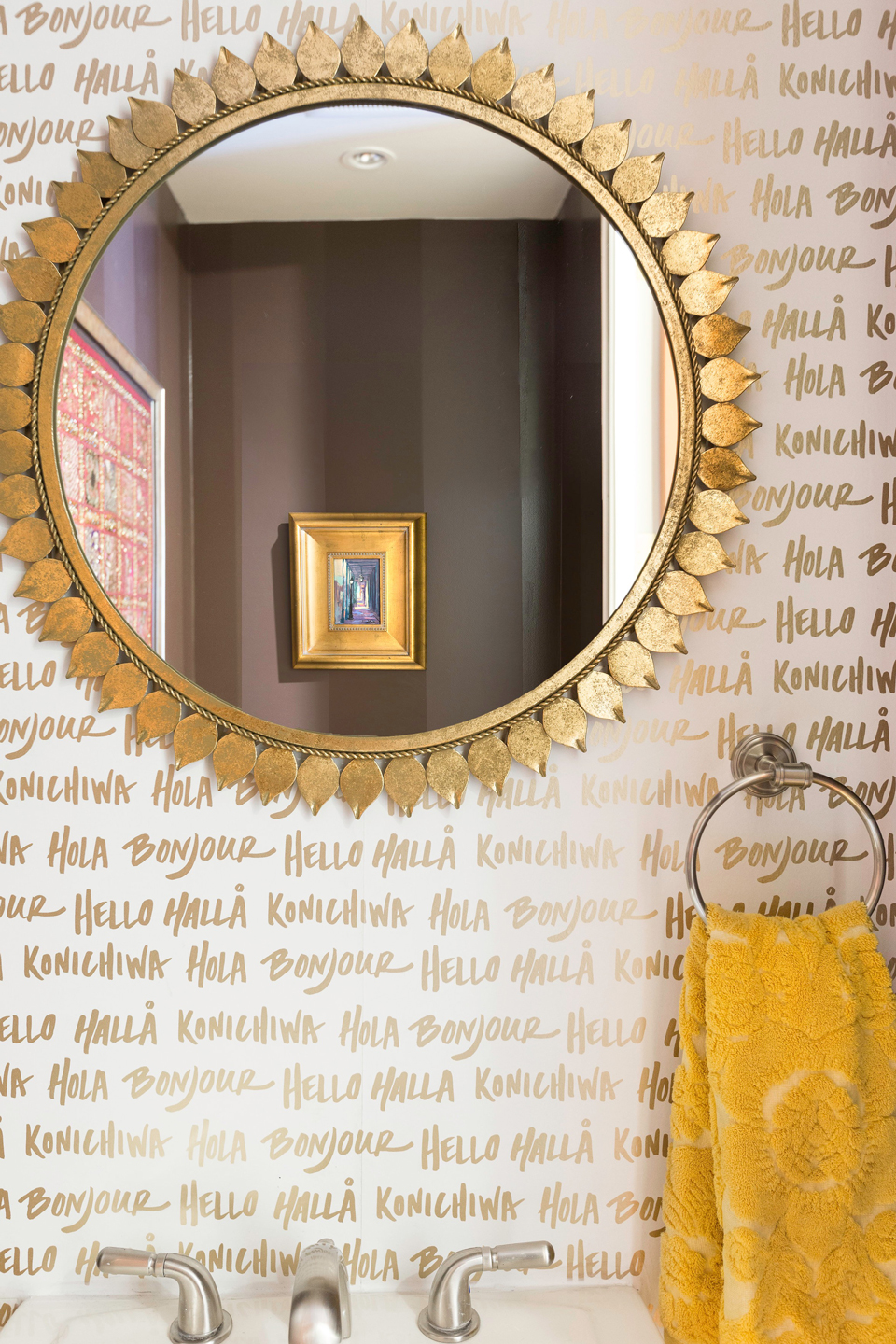 White wallpaper with gold lettering in a bathroom