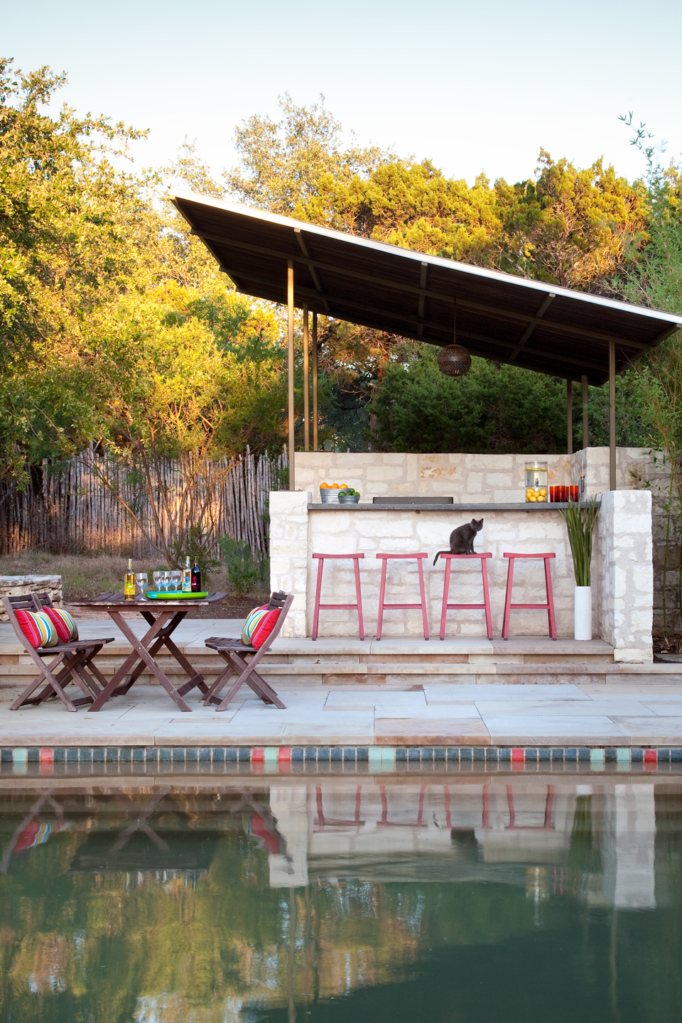 An after image of a midcentury pool with bar and stools
