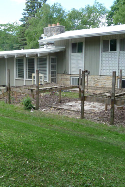 A before image of a front yard with wood risers for deck