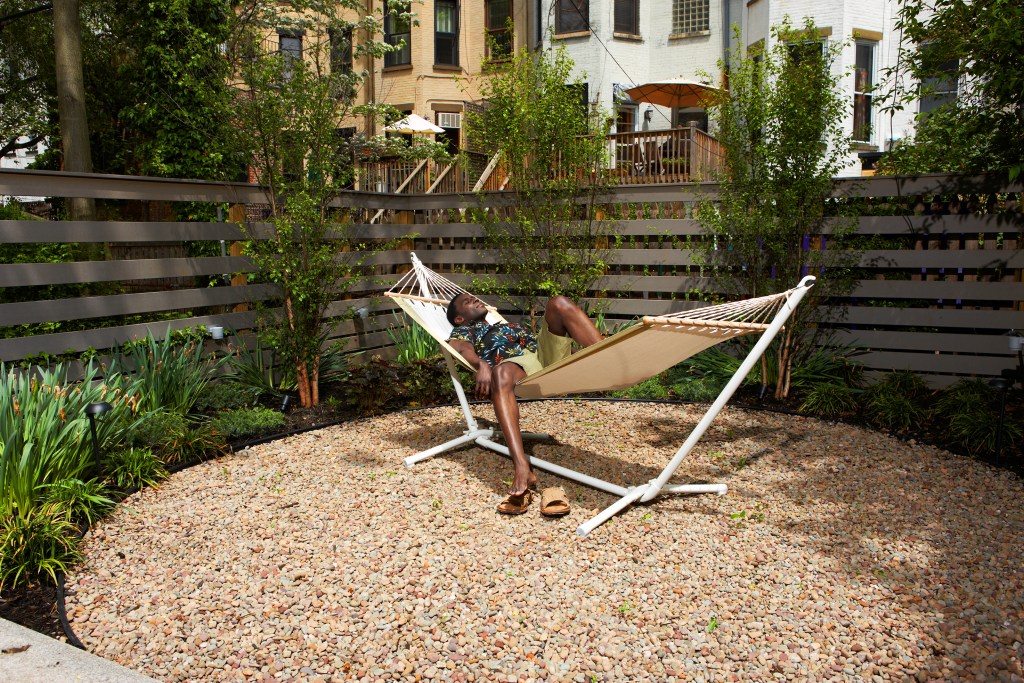 Man relaxing on a hammock in an urban back yard
