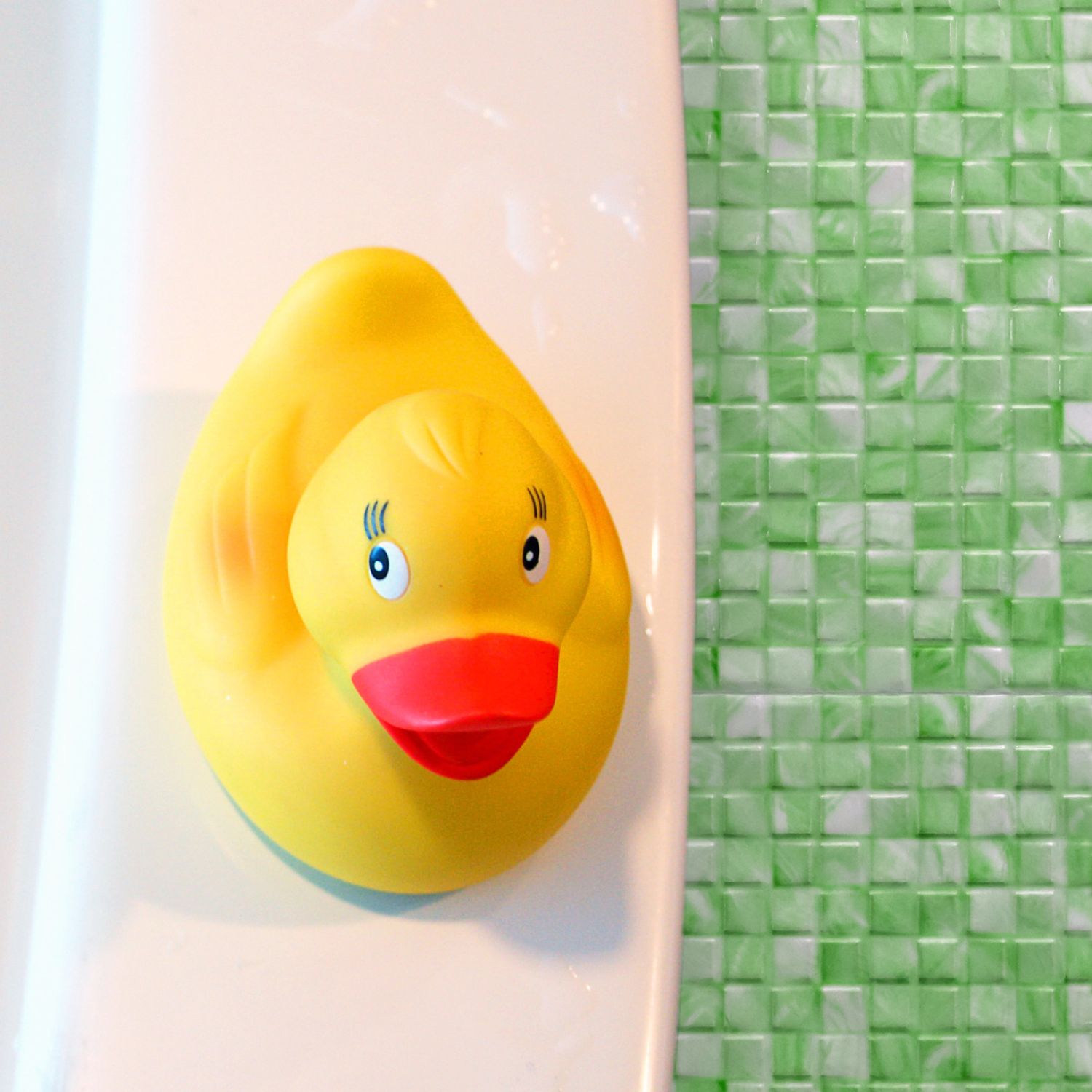 Rubber ducky on a tub in a bathroom