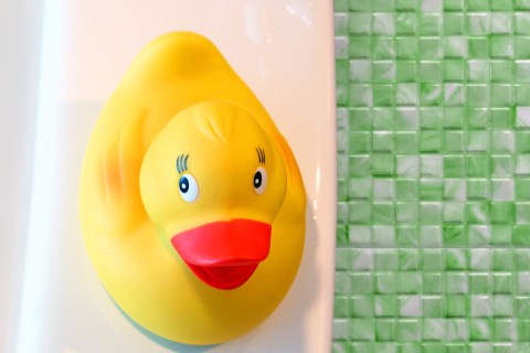 Rubber ducky on a tub in a bathroom
