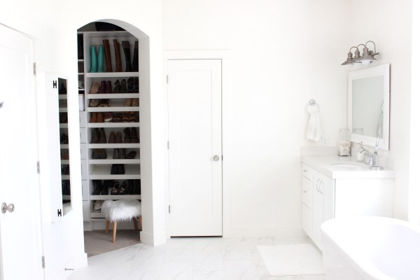All white bathroom with glimpse of a shoe closet