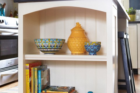 Organize shelf in kitchen with yellow pots and cookbooks