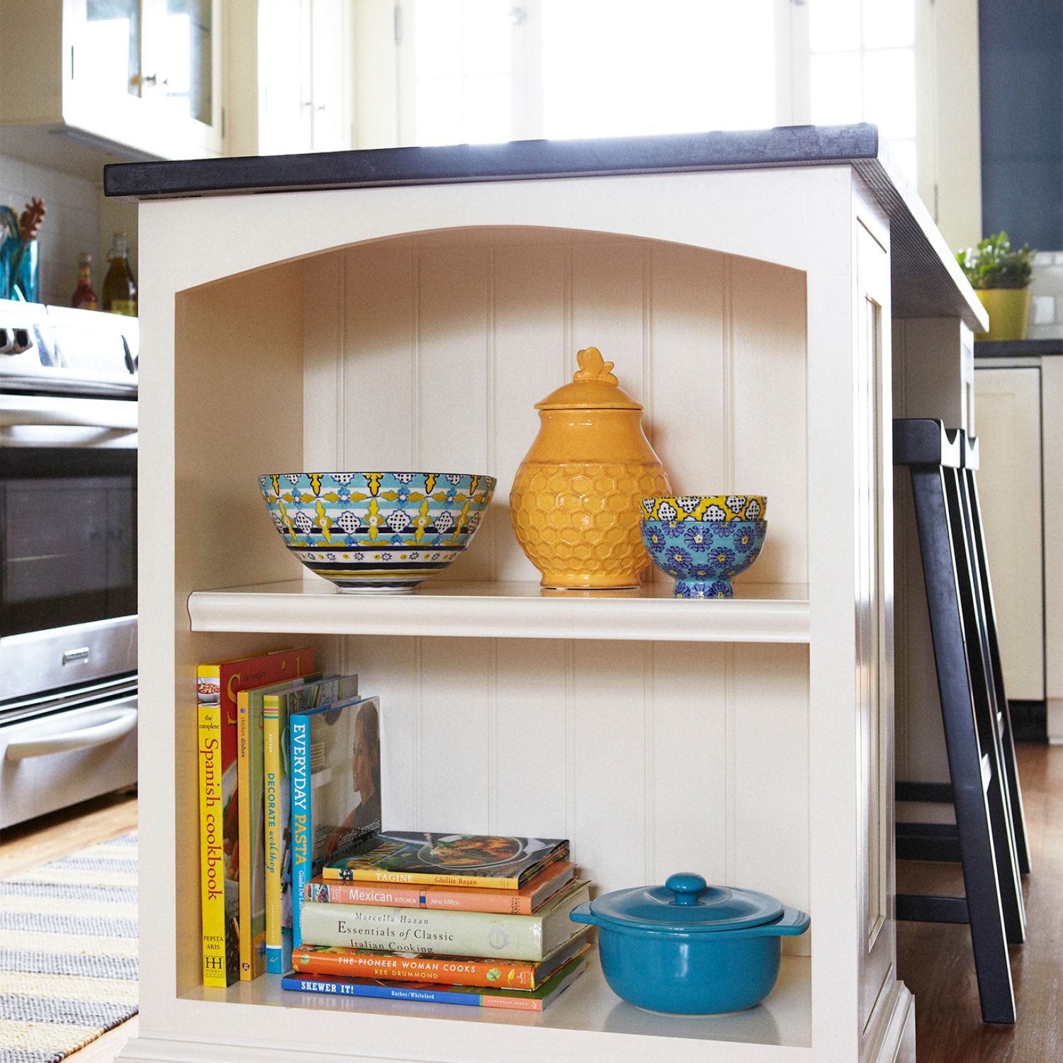 Organize shelf in kitchen with yellow pots and cookbooks