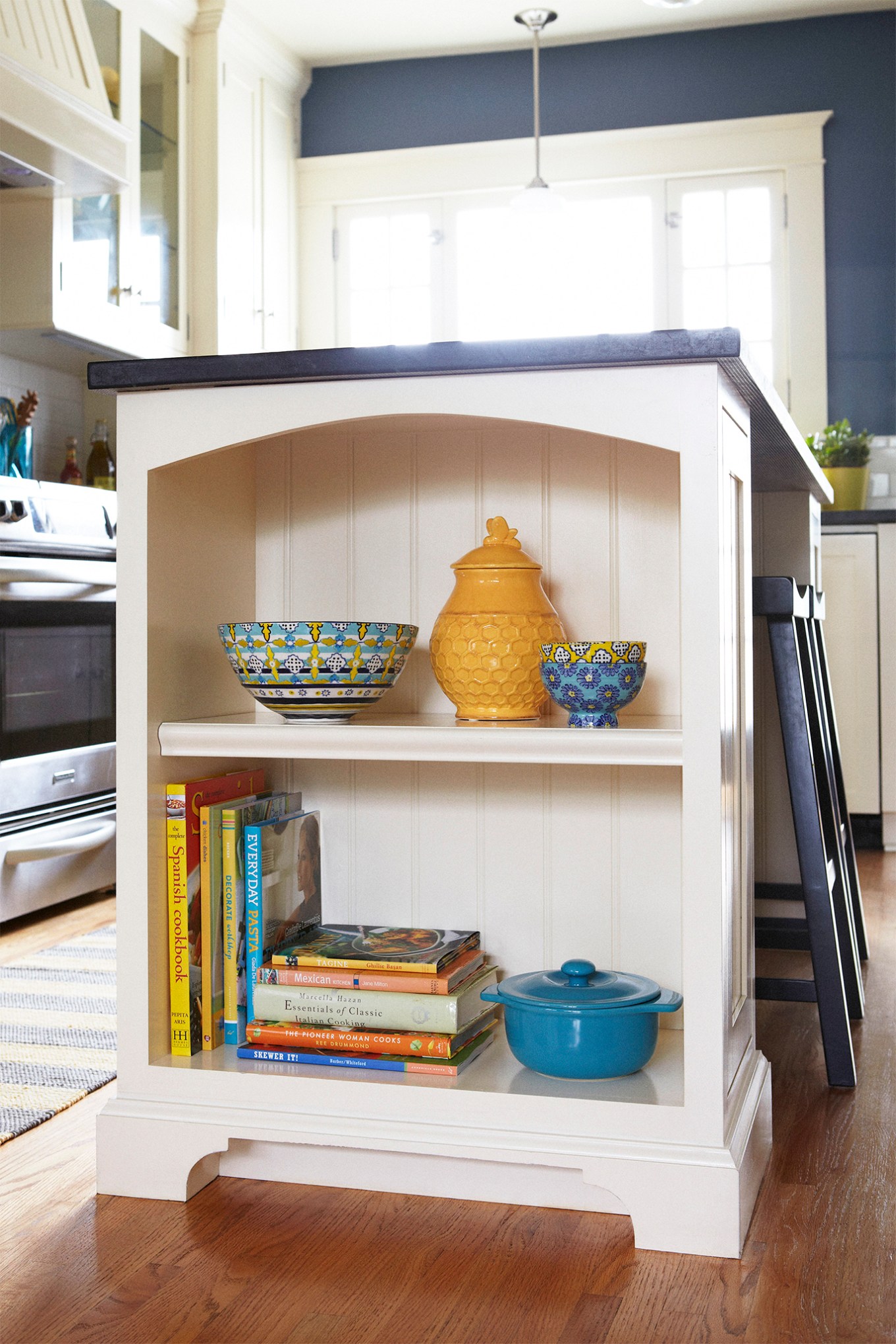 Organize shelf in kitchen with yellow pots and cookbooks