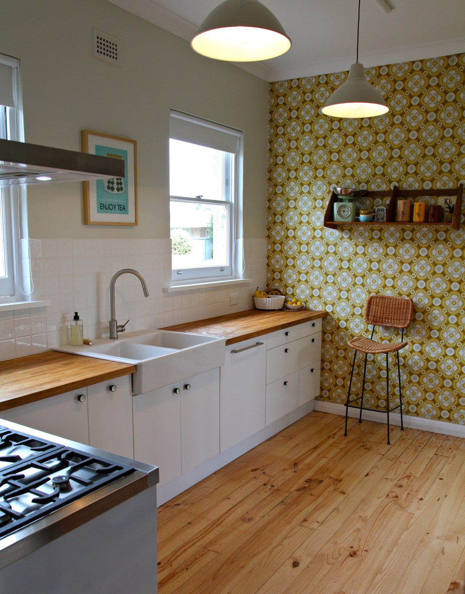 Remodeled kitchen with white cabinets, patterned accent wall