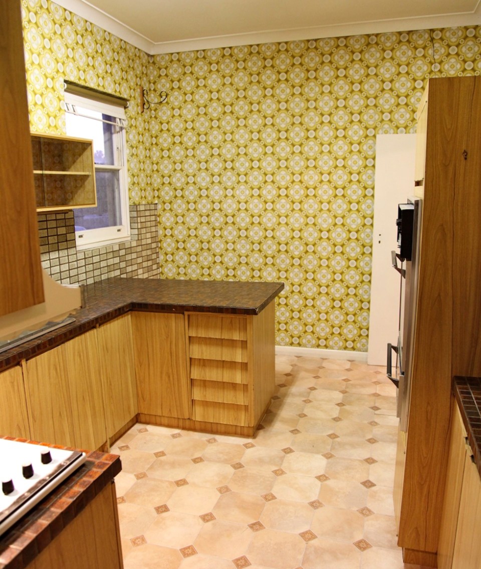 Seventies-style kitchen with brown cabinets, patterned walls