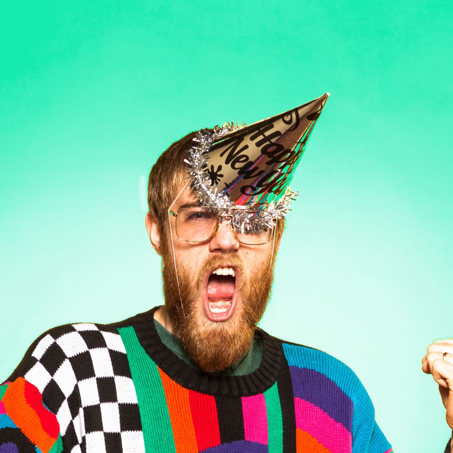 Bearded man in ugly sweater with New Year's party hat