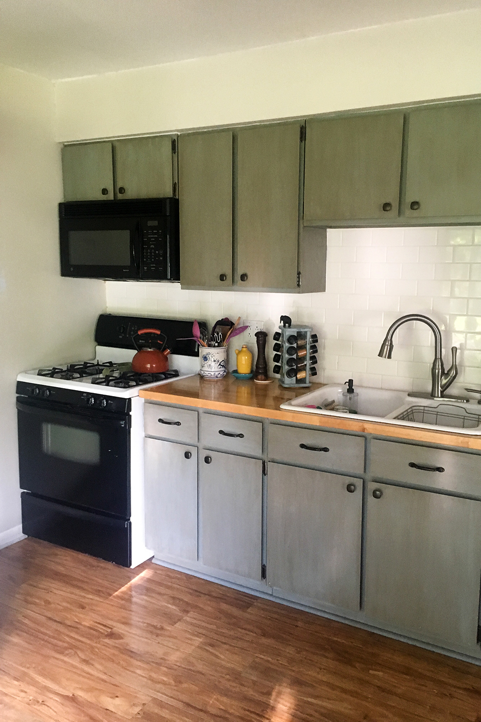 Olive and gray kitchen cabinets awaiting door replacement