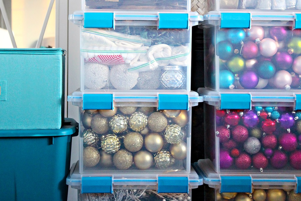 Holiday decorations stacked in large, clear plastic tubs