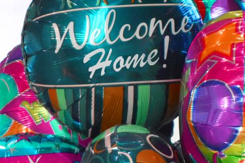 Assortment of foil balloons that say, "Welcome home!"