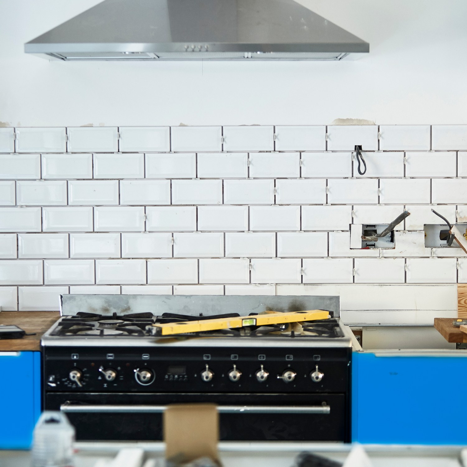 White kitchen mid remodel with blue cabinets being installed
