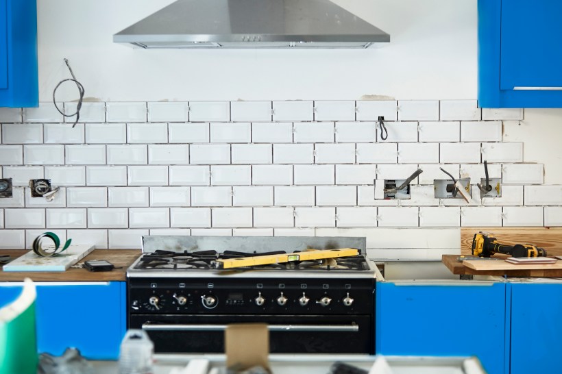 White kitchen mid remodel with blue cabinets being installed