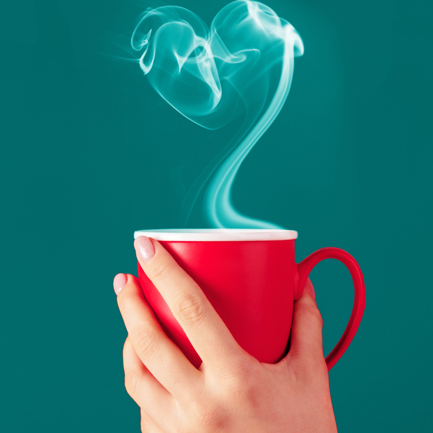 Hand holding red mug with heart-shaped smoke from beverage