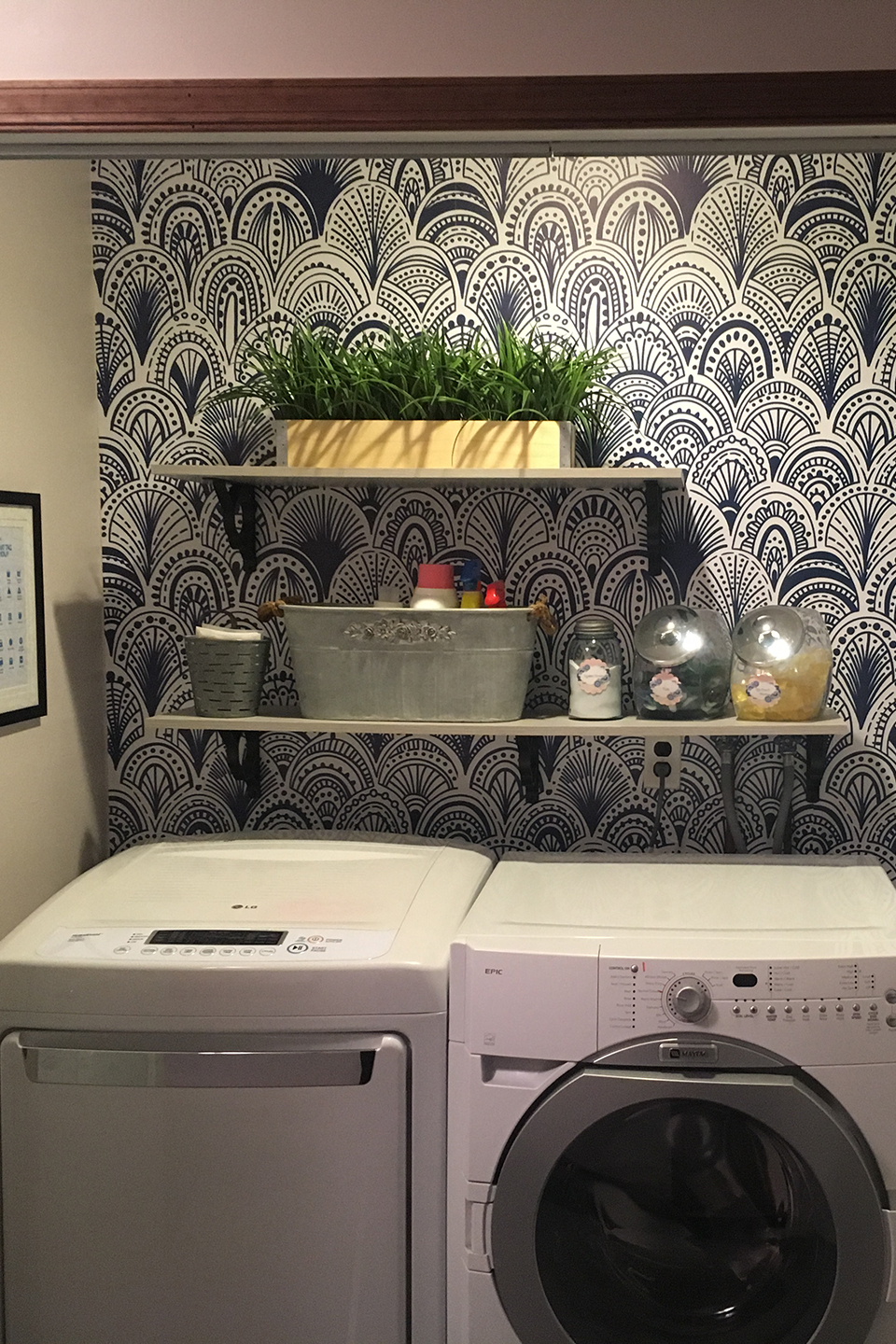 Neatly organized laundry closet with shelves and wallpaper