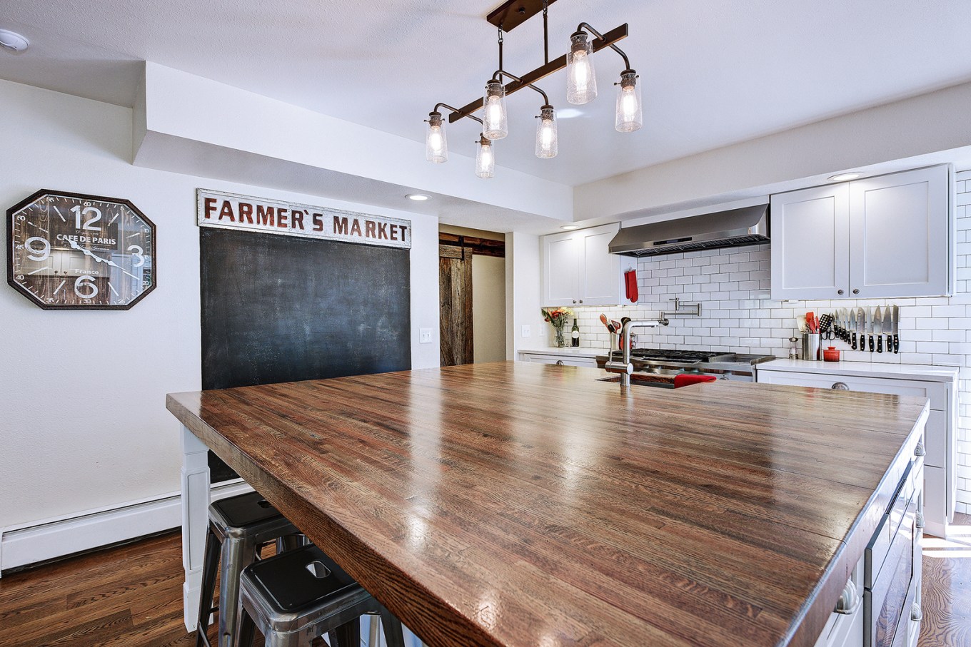 Large wooden kitchen island in front of chalk board