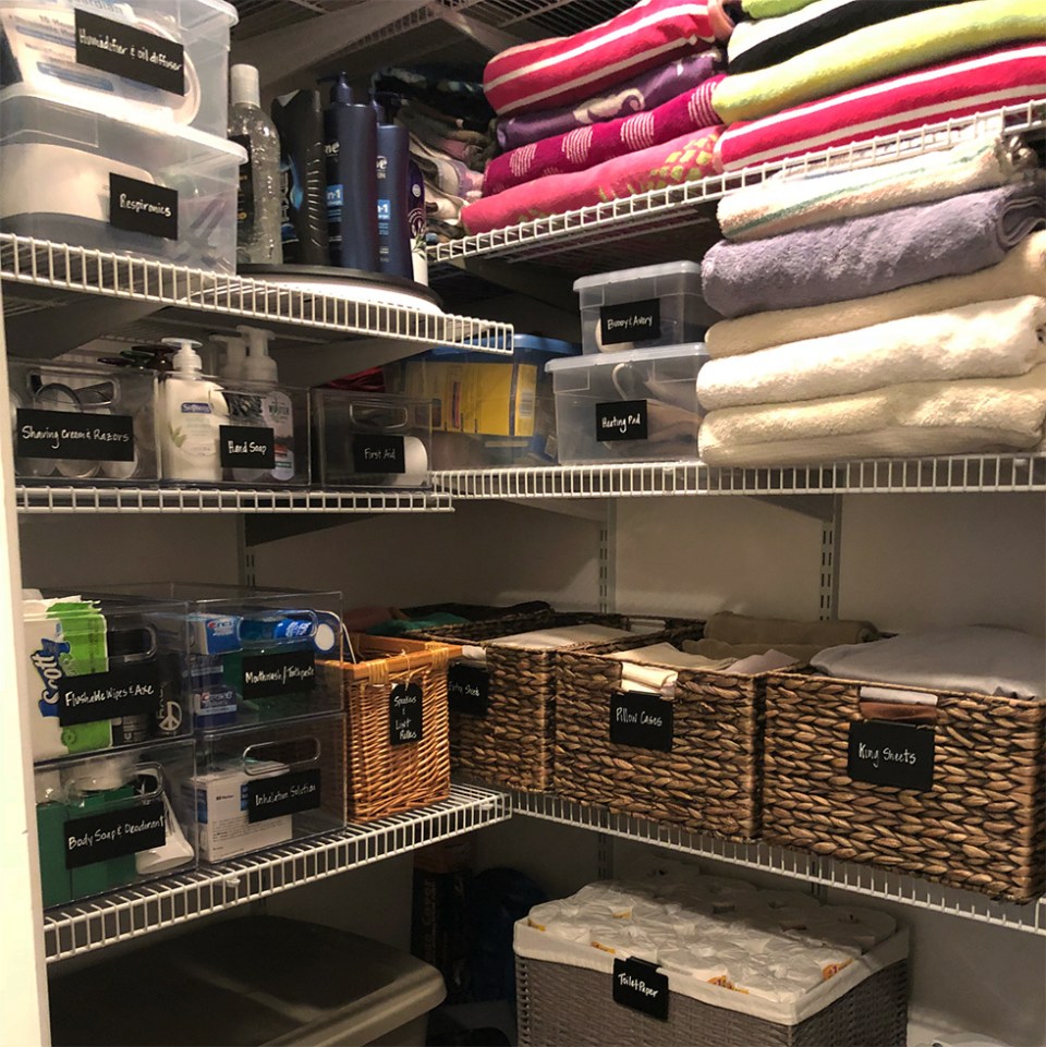 Linen closet organized with baskets, bins, and labels