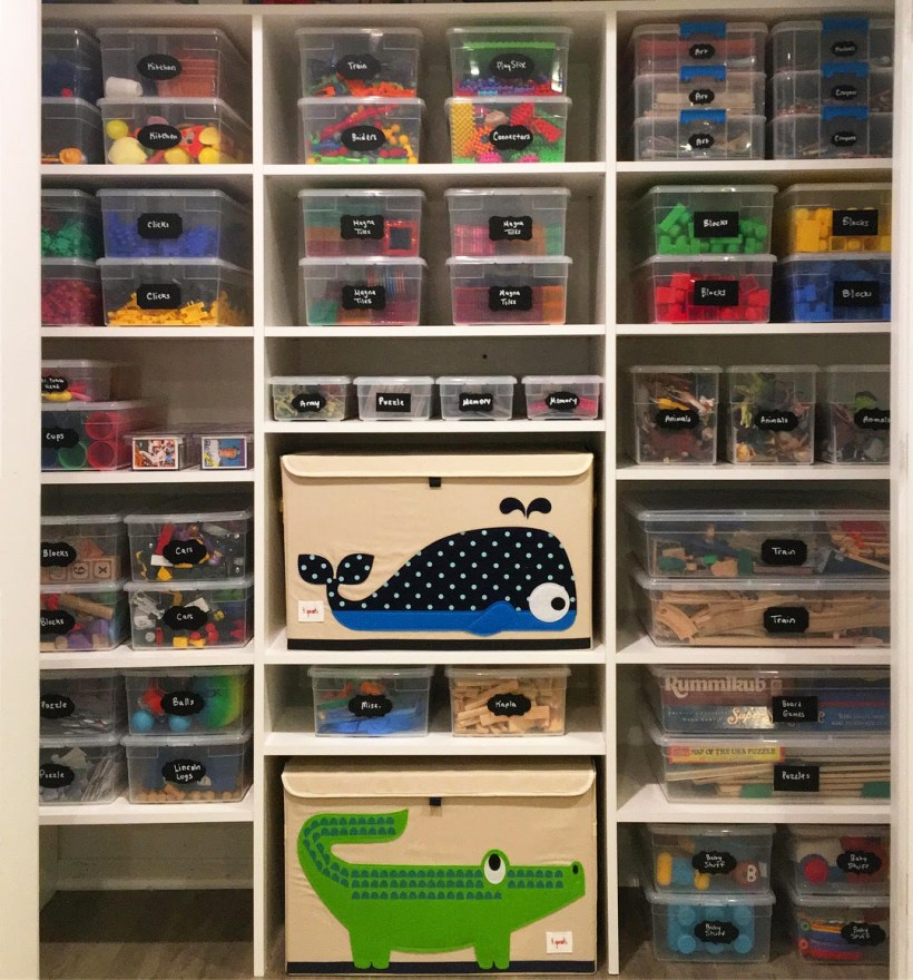 Playroom closet full of toys organized in clear bins