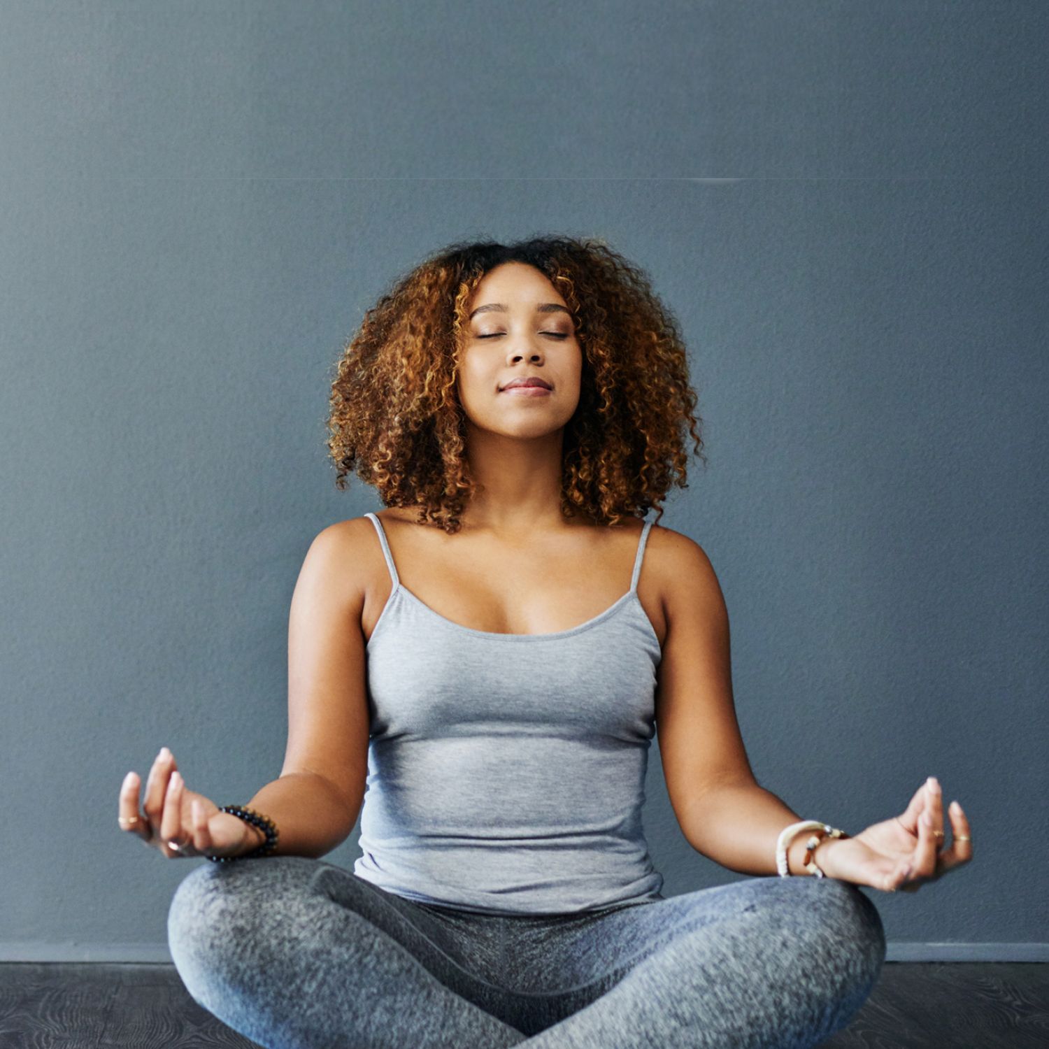 Woman in lotus pose meditating with eyes closed on yoga mat
