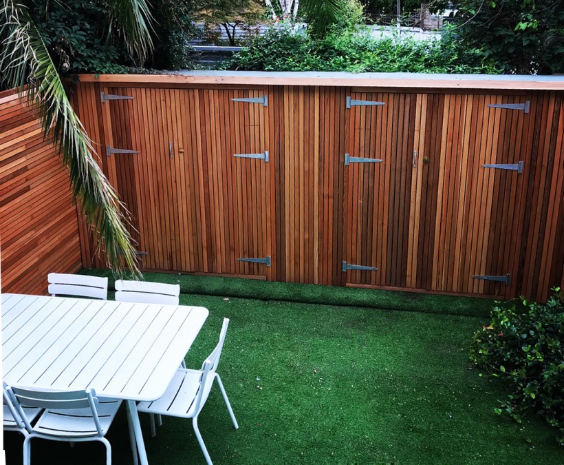 Outdoor storage sheds built in to a backyard fence
