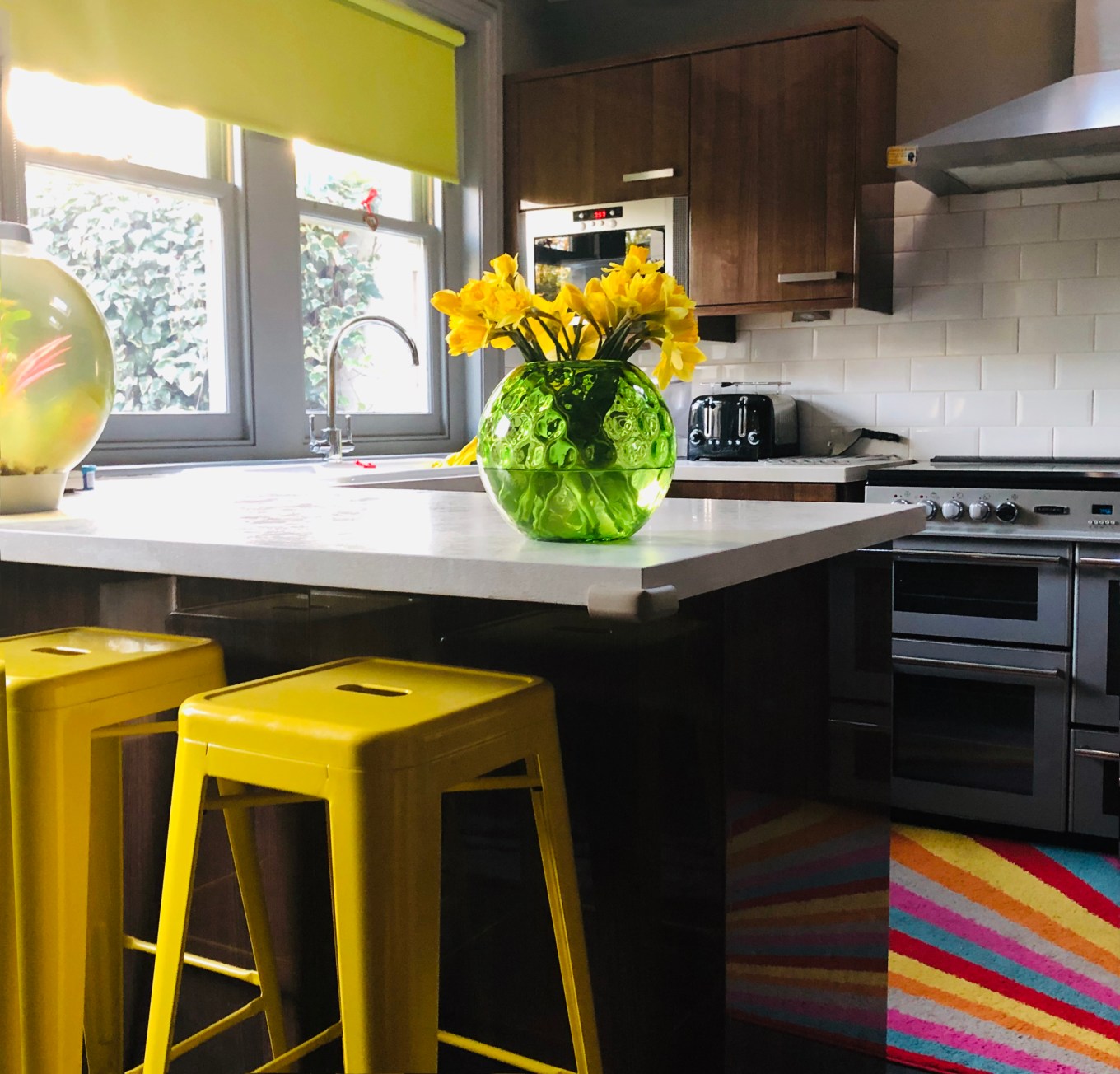 Sunny kitchen with neutral countertop and bright yellow tolix stools