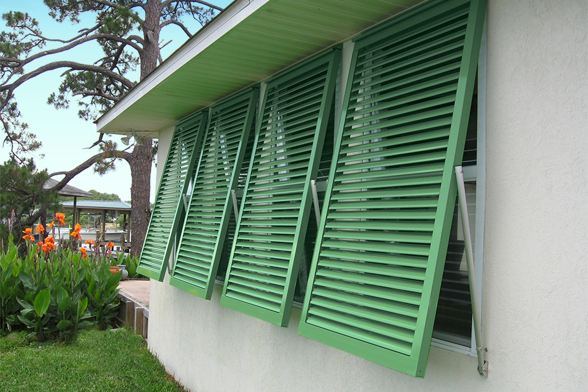 Green hurricane shutters installed at a house