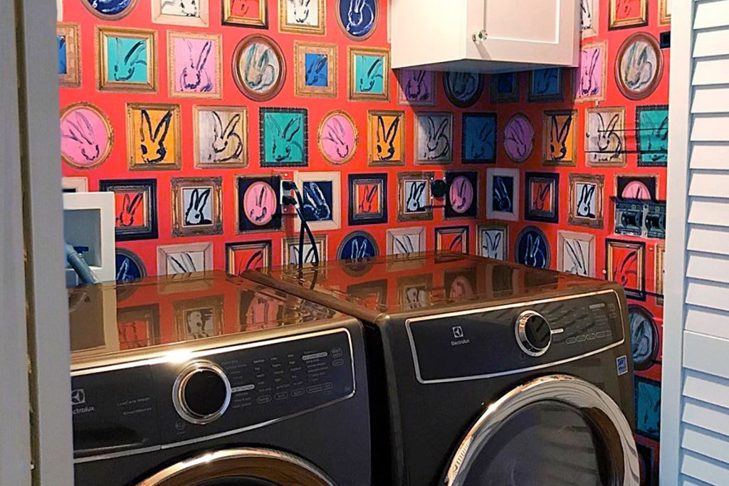 Laundry nook with colorful red wallpaper and bifold door