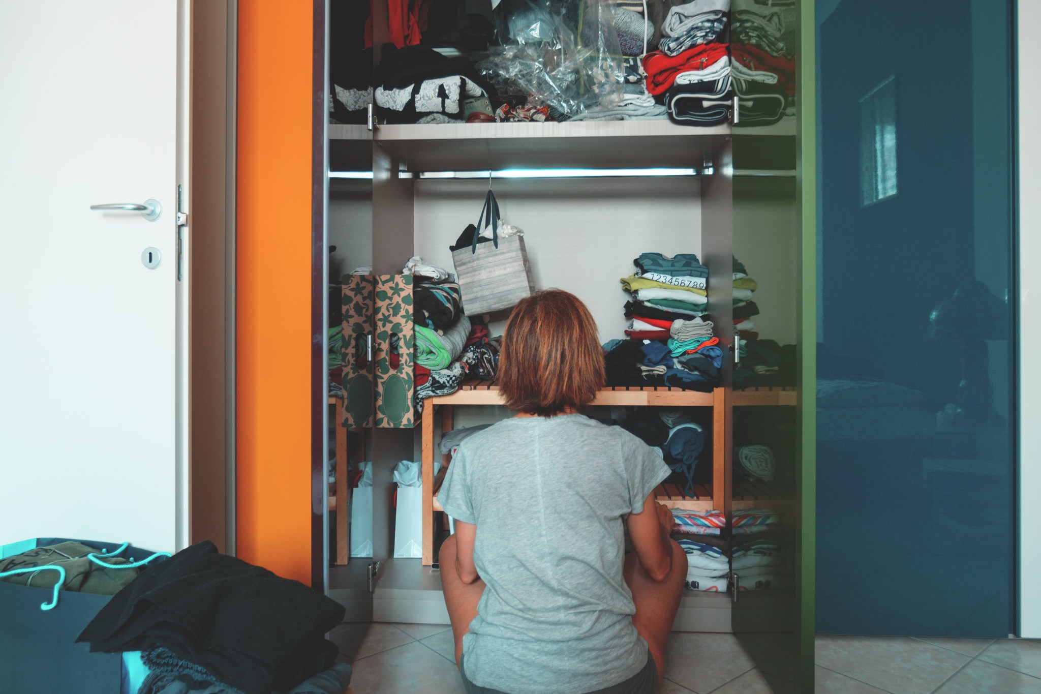 clutter-depression-woman-looking-at-full-closet