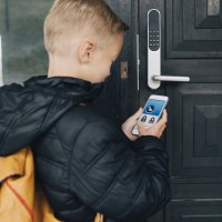 smart home security overview boy using mobile phone to unlock smart lock
