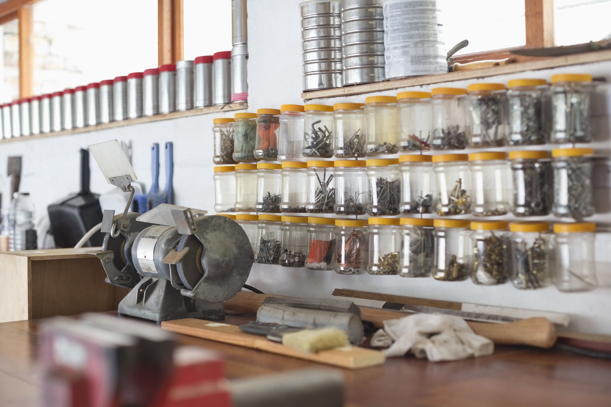 A garage workstation with neatly organized nuts, bolts, and more on the wall.