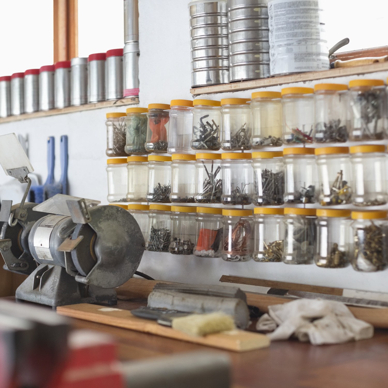 A garage workstation with neatly organized nuts, bolts, and more on the wall.