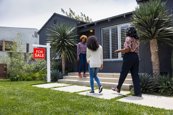 Real estate agent meets family for a tour of a for-sale house.