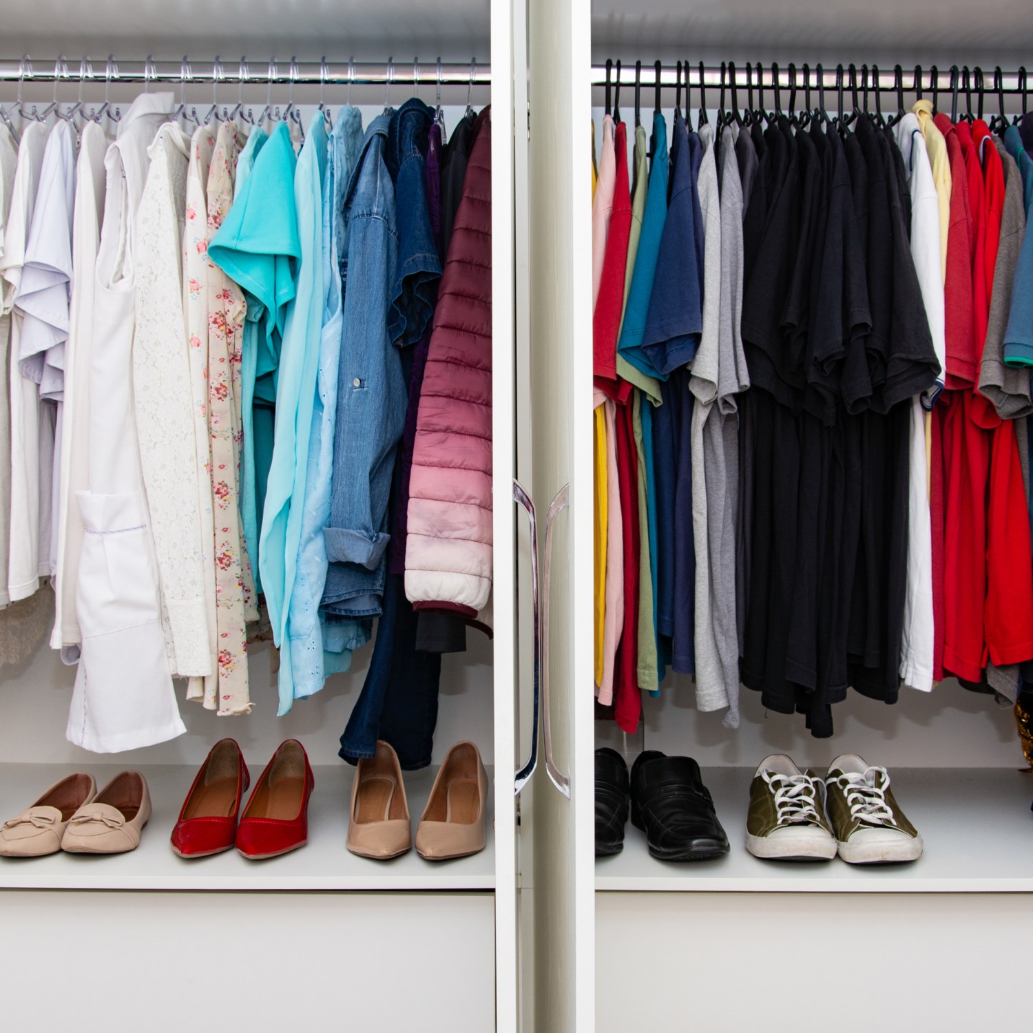 A custom built closet for a married couple with color organized clothing.