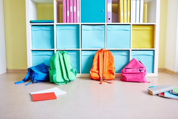 ack to school home organization image of shelves with notebooks and bins and multi colored backpacks