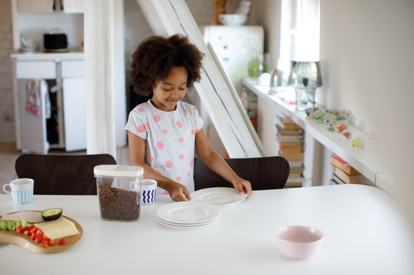 back to school home organization 7 year old girl sets the table for breakfast