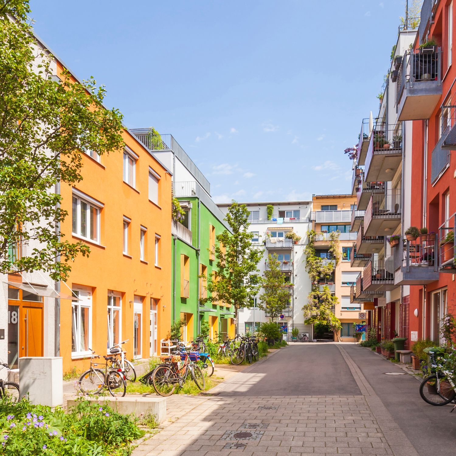buying a single family home or condo view of colorful condo building with patios overlooking courtyard with bicycles and green trees