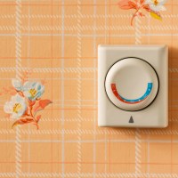 common easy home mistakes old thermostat on peach and floral wallpaper