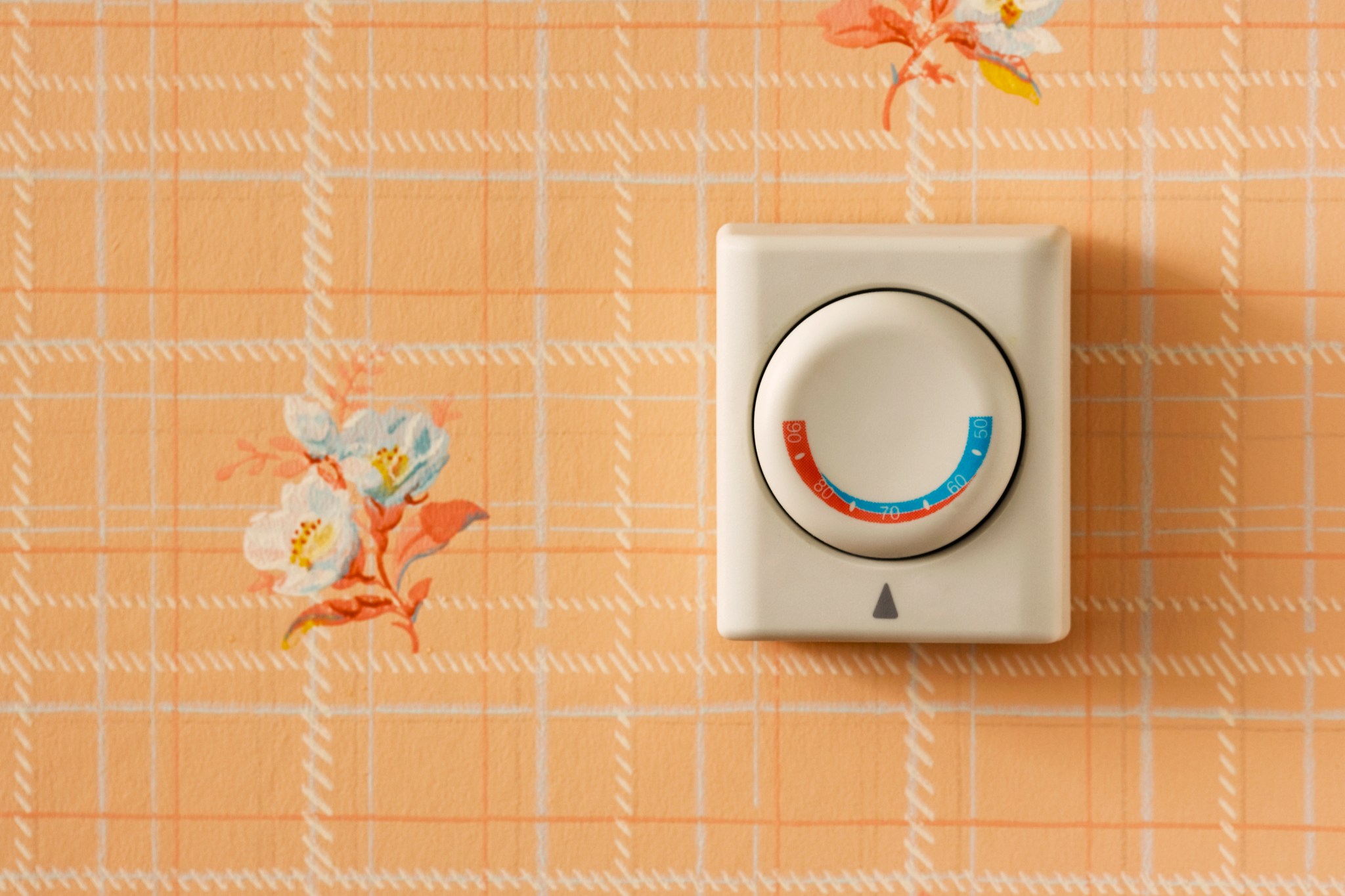 common easy home mistakes old thermostat on peach and floral wallpaper