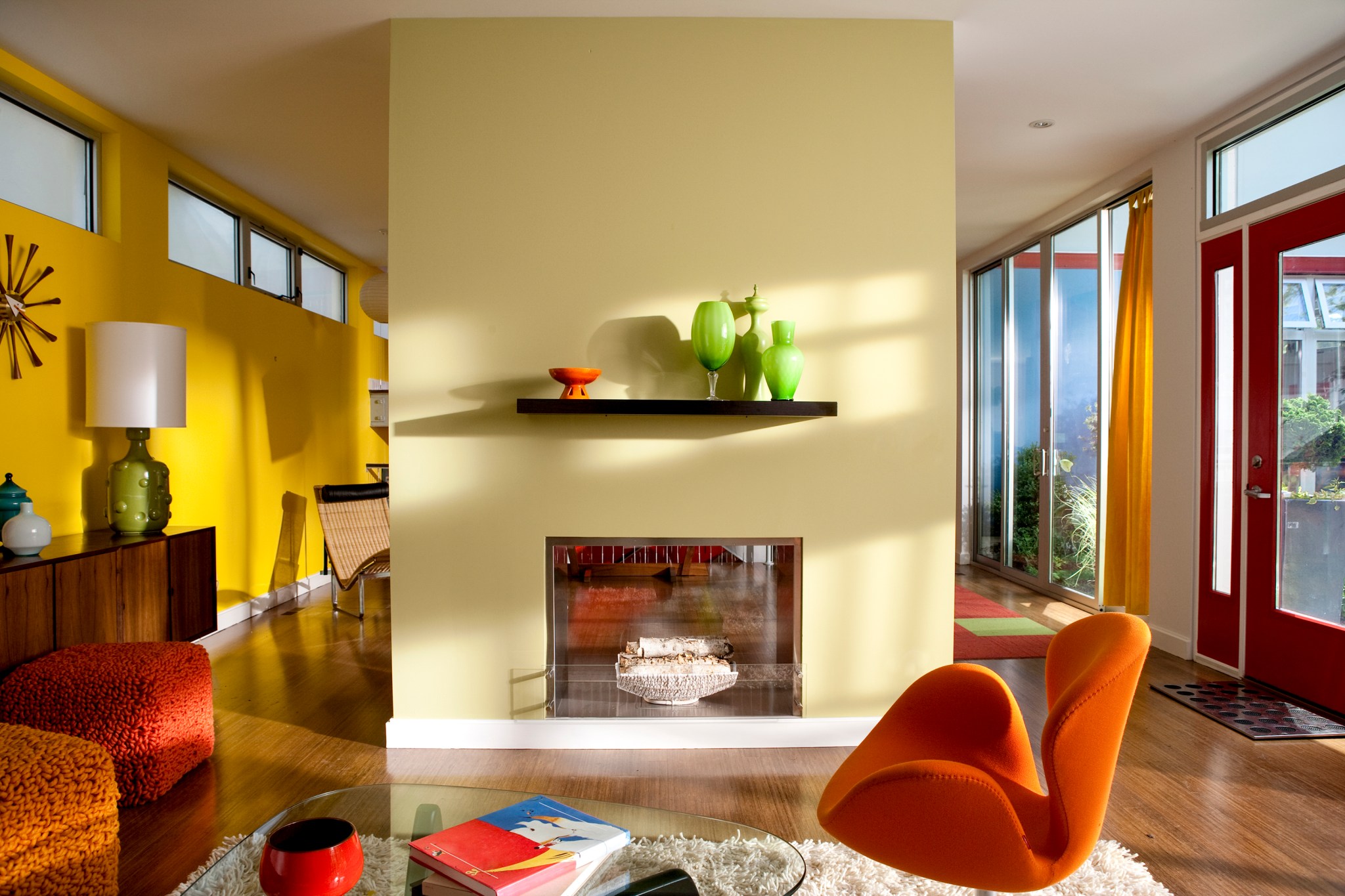 how much does it cost to paint your house image of a mid century modern home painted with bright and warm hues of yellow and orange with green accents and a dual sided fireplace as a focal point