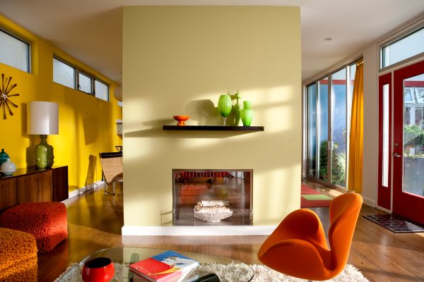 how much does it cost to paint your house image of a mid century modern home painted with bright and warm hues of yellow and orange with green accents and a dual sided fireplace as a focal point