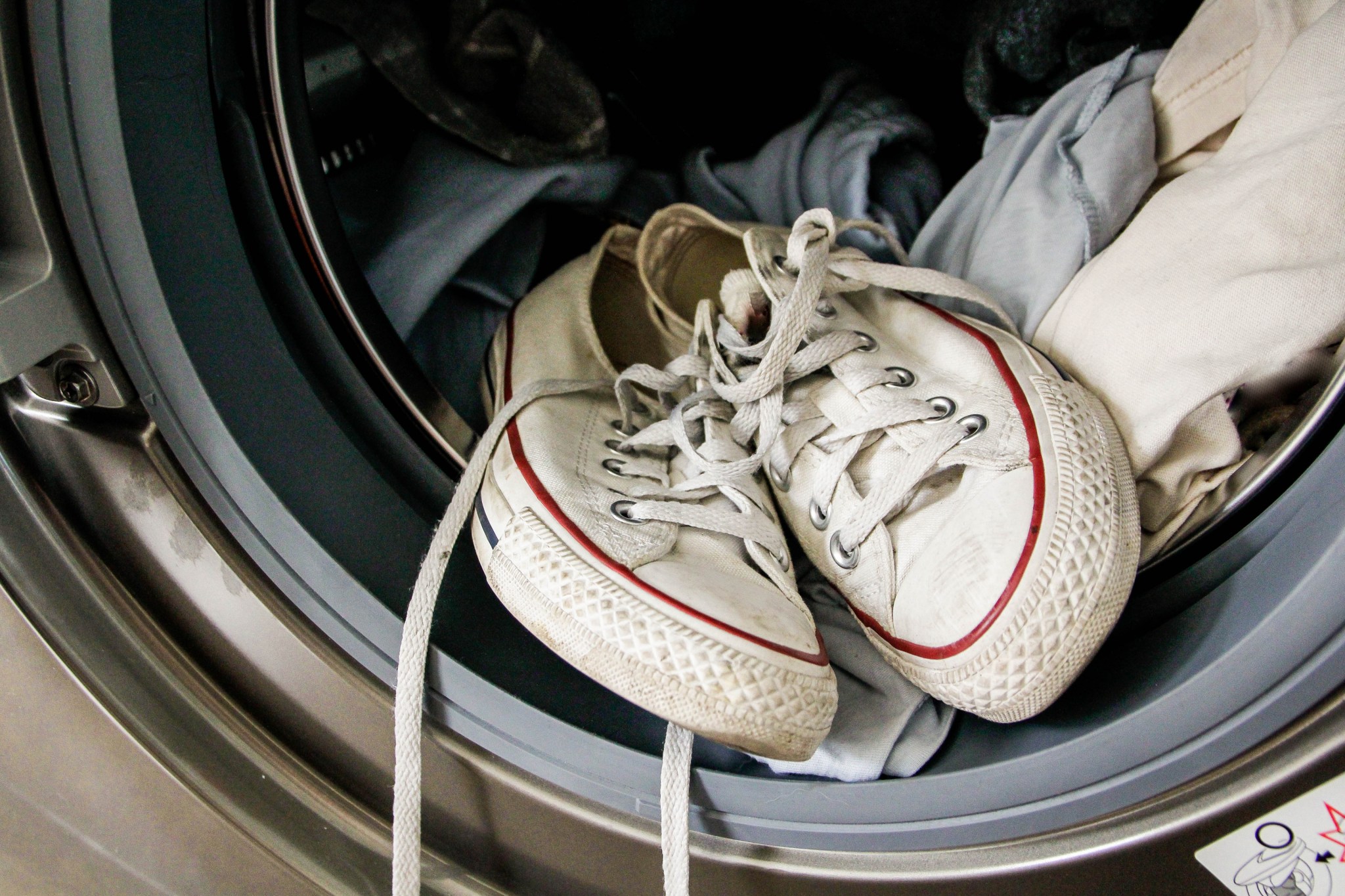 wash just about anything image of dirty white sneakers and t-shirts in a front load washing machine